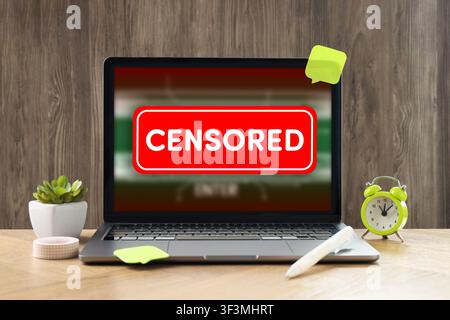 Censored content. Laptop displaying notification on desk Stock Photo