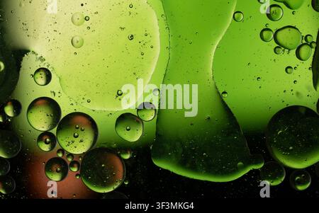 Green oil droplets and bubbles floating in an abstract liquid background Stock Photo