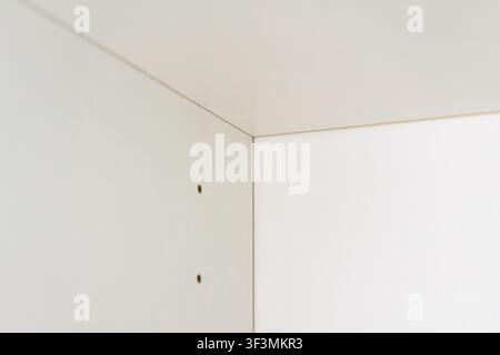Minimalist interior detail showing a junction of two walls with a faint shadow cast from an unseen object Stock Photo