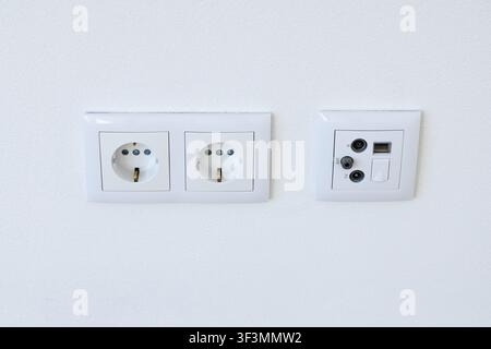 A close-up view of a double European power socket and a combined media plate with TV, SAT, and RJ45 connectors Stock Photo