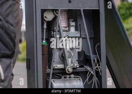 Close-up of the internal mechanism of an automatic barrier gate showing the electromechanical drive, springs, control components and wiring inside the Stock Photo