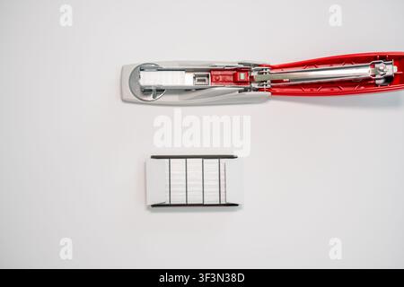 Open red stapler and staple strip isolated on white background, office supply concept. Stock Photo