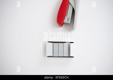 Open red stapler and staple strip isolated on white background, office supply concept. Stock Photo