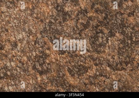 A high-resolution texture of tiger granite showing deep brown and gold swirls with natural mineral veining. Stock Photo