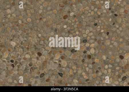 An overhead close-up of exposed aggregate concrete, featuring a variety of colorful smooth river pebbles embedded in a solid cement base. Stock Photo