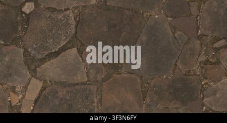 An overhead view of a textured flagstone path made of dark, irregular slate pieces fitted together with grout. Stock Photo