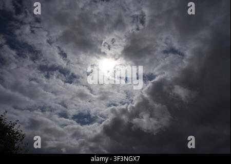 Dramatic cloud formations with bright light in the center, weather photo, a mix of sun and clouds above 27798 Hude, Oldenburg district, Germany Stock Photo