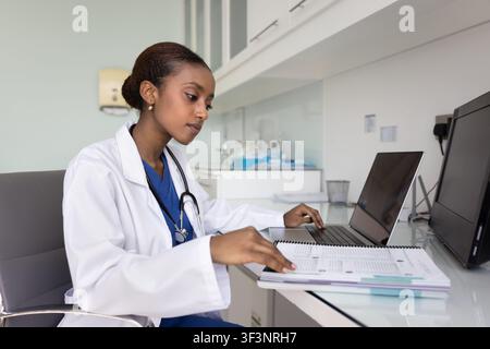 Focused young African American medical intern woman doing research Stock Photo