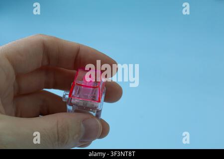 Macro Close-Up of Transparent Mechanical Keyboard Switch Held Between Fingers Stock Photo