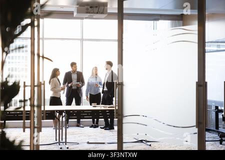 Diverse businesspeople engaging in collaborative meeting in conference room Stock Photo