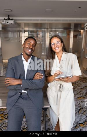 Portrait of smiling diverse team members standing in corporate office Stock Photo