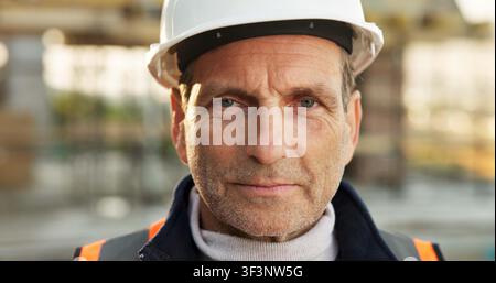 Construction, portrait or engineer on site with hardhat, contractor or about us in industrial industry. Space, architect or mature man with ppe helmet Stock Photo