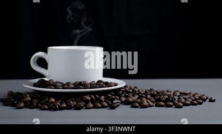 Steaming White Coffee Cup with Roasted Beans on Dark Background Stock Photo