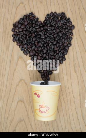 Heart Shape Roasted Coffee Beans Pouring from Paper Cup Stock Photo
