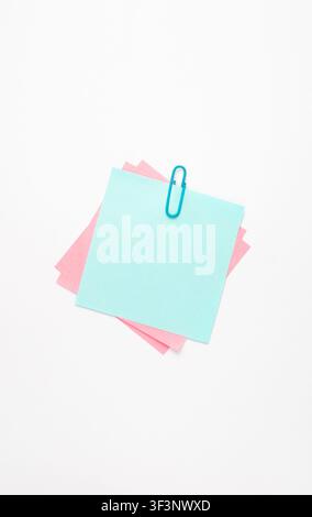 Pastel Sticky Notes with Blue Paper Clip on White Background Stock Photo