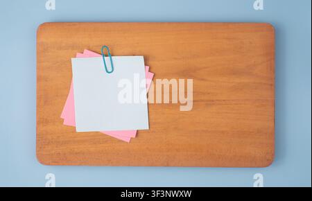 Pastel Sticky Notes with Clip on Wooden Board Stock Photo