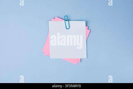 Pastel Sticky Notes with Paper Clip on Blue Background Stock Photo