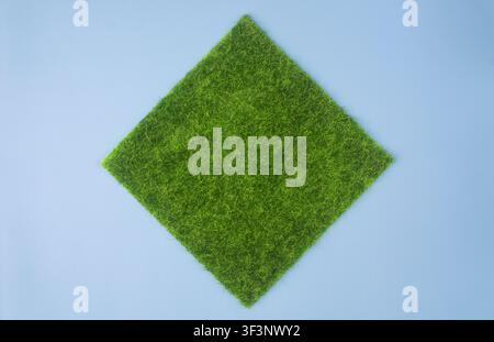 Square Green Grass Patch on Blue Background Top View Stock Photo