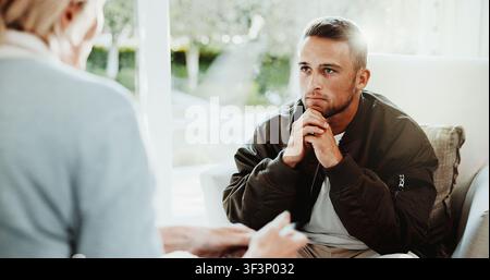 Psychology, therapist and man in consultation, listening or stress for mental health evaluation. Counseling session, patient and person with thoughts Stock Photo
