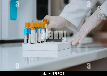 Laboratory Technician Handling Blood Test Tubes With Gloved Hands In Medical Clinical Lab Stock Photo