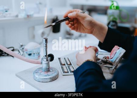 Dental Technician Working on Dentures in a Dental Lab Using Torch for Prosthetic Teeth Restoration Stock Photo