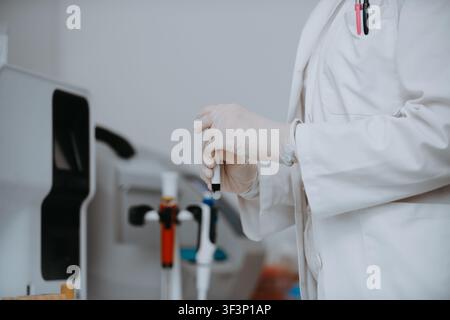 Medical Professional In Lab Coat Wearing Gloves And Preparing A Sample With A Pipette In Laboratory Stock Photo