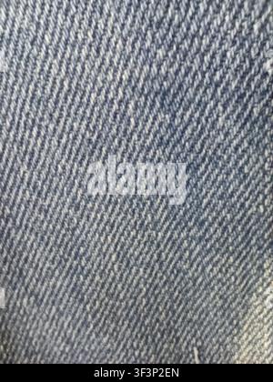 Full frame macro photograph of blue denim jeans textile material showing diagonal twill pattern and cotton fibers Stock Photo
