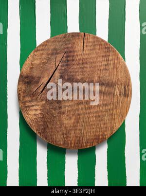 old empty wooden cutting board on green and white striped painted background, top view, Flat lay concept for menu or recipe, High angle view of a blan Stock Photo