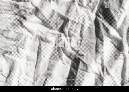 Crumpled fabric forming an abstract textured background with halftone dots Stock Photo