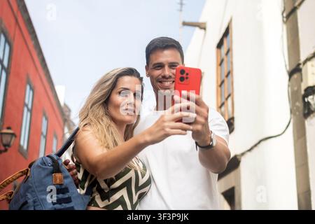 Young travel couple using a smartphone while exploring a historic city. Stock Photo
