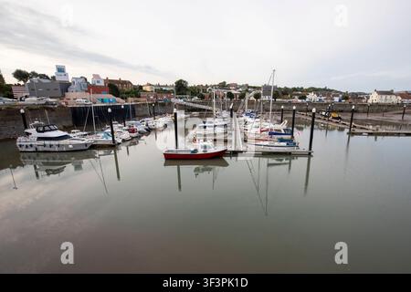 Yachts and motorboats moored on pontoons in the calm waters of Watchet Harbour Marina at dusk in Watchet, Somerset, England, UK. Stock Photo