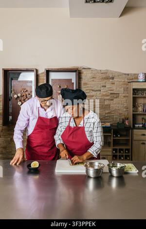 Chefs preparing ingredients during cooking course in restaurant kitchen Stock Photo
