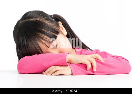 Overworked schoolgirl sleeping on desk after long time study Stock Photo