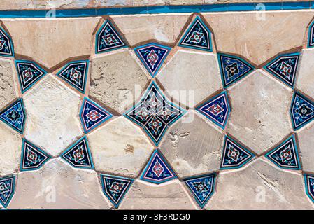 Traditional Oriental mosaic and brickwork featuring turquoise and blue glazed tiles. This Islamic-style geometric pattern is perfect as a background f Stock Photo