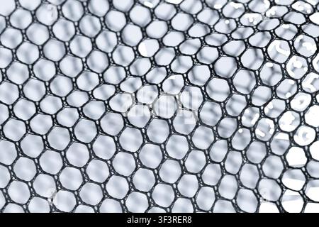 Black mesh fabric texture isolated on white background. Industrial net material. Stock Photo