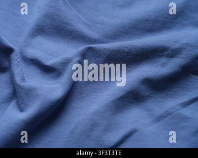 A close-up texture of soft wrinkled blue jersey fabric. Stock Photo
