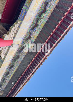 Low angle view of painted roof eaves at the Forbidden City Palace Museum near Tiananmen Square in Beijing, China, with blue sky Stock Photo