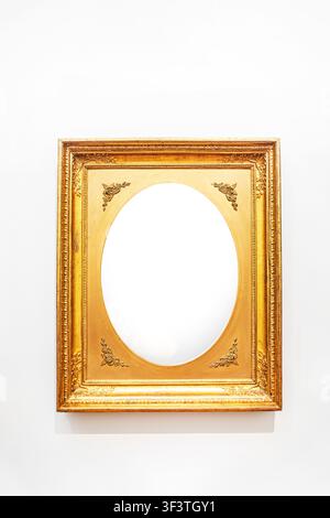 Gilded wooden rectangular frame with vignettes along the edges and an oval inside Stock Photo