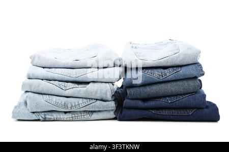 Two stacks of folded blue jeans in various shades of denim, casual fashion and apparel concept, isolated on a white background Stock Photo