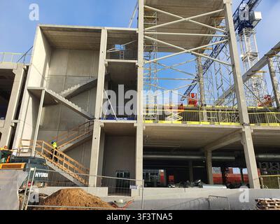 A large-scale commercial building construction site featuring exposed reinforced concrete columns, beams, and floor slabs forming a multi-level Stock Photo