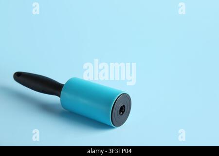 Lint roller on blue background Stock Photo
