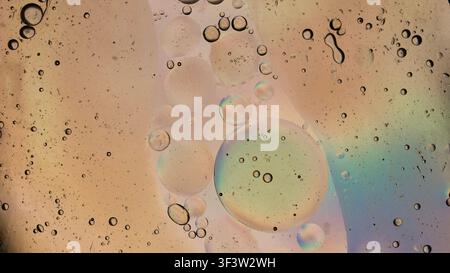 Oil and water droplets mixing in an iridescent abstract liquid composition Stock Photo