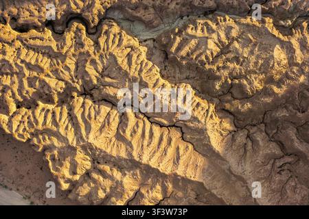 Close-up of colorful desert formations shaped by erosion, showing intricate ridges and cracks in sunlit rock. Natural abstract background texture phot Stock Photo