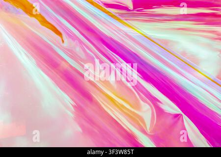 A vibrant holographic surface with bright, flowing rainbow colors creating an abstract and dynamic background. Shiny and colorful, this image is perfe Stock Photo