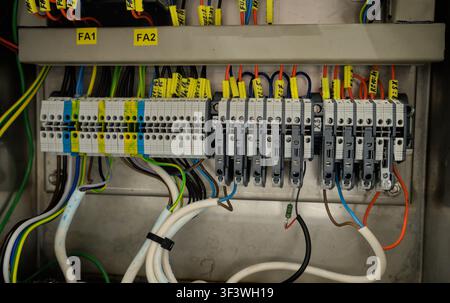 Industrial electrical control panel with terminal blocks and wiring inside a machine cabinet. Stock Photo