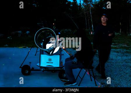 At dusk, the team of scientists sets up a mobile Meade telescope on the grounds of the Deep Sky Eye Observatory on Frotten Road in the Municipality of Argyle, Nova Scotia, Canada. The public telescope is mounted on a trolley and can be moved freely around the site Stock Photo