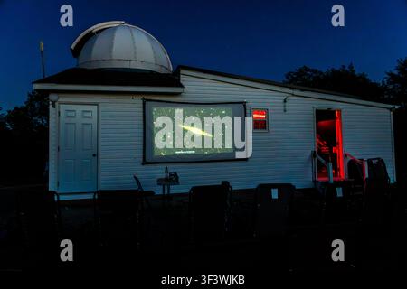 At the Deep Sky Eye Observatory on Frotten Road in the Municipality of Argyle, Nova Scotia, Canada, a projector displays an image of a galaxy onto the outer wall of the domed building. Red lighting in the door and windows ensures that visitors’ night vision is not impaired during the evening show. Argyle Municipal, Nova Scotia, Canada Stock Photo
