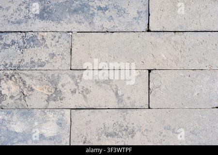 Light Gray Limestone Block Wall Texture Background with Weathered Natural Stone Pattern. Stock Photo