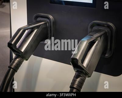 Close-up of two Type 2 charging connectors plugged into an EV charging station, showing the standard AC charging interface widely used for electric ve Stock Photo