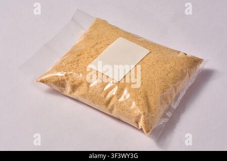 biscuit powder in clear plastic bag isolated white background, crushed cookies with blank white label for branding, packaging mock-up template Stock Photo